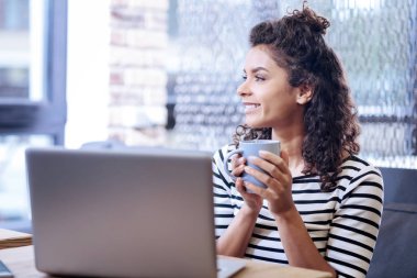 Pencereden dışarı bakarak ve onun Kupası holding neşeli kız