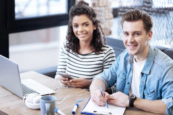 Kräftige junge Frau und Mann sitzen gemeinsam am Tisch — Stockfoto