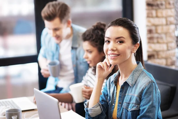 Bella ragazza seduta con il suo computer portatile e sorridente — Foto Stock