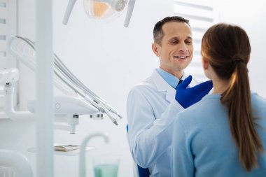 Hastalar çenesini tutarak neşeli iyi adam