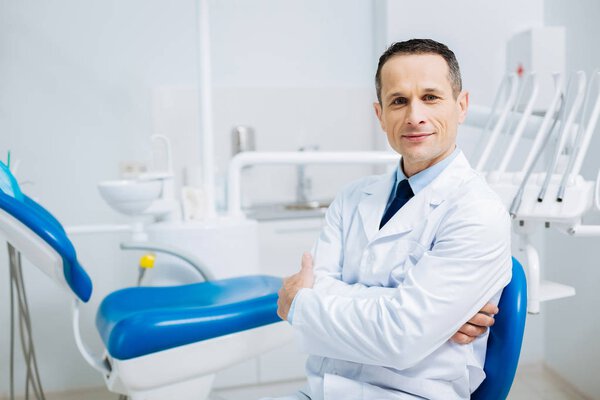 Handsome delighted doctor looking at you