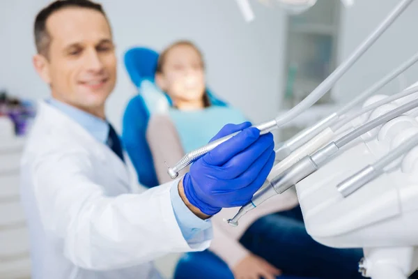 Mooie aangename tandarts nemen zijn tandheelkundige freesmachine — Stockfoto