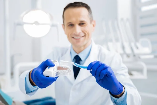 Blij aardige arts tonen hoe borstel tanden — Stockfoto