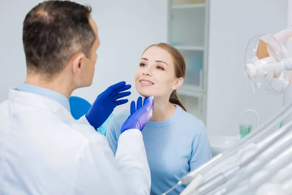 Nice pleasant woman looking at her doctor — Stock Photo, Image