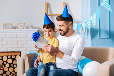 Mutlu baba ve oğlu onun doğum günü hediyesi incelenmesi