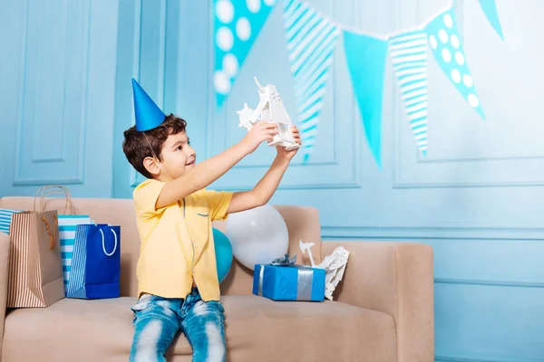Приємний маленький хлопчик захоплюється своїм подарунком на день народження — стокове фото
