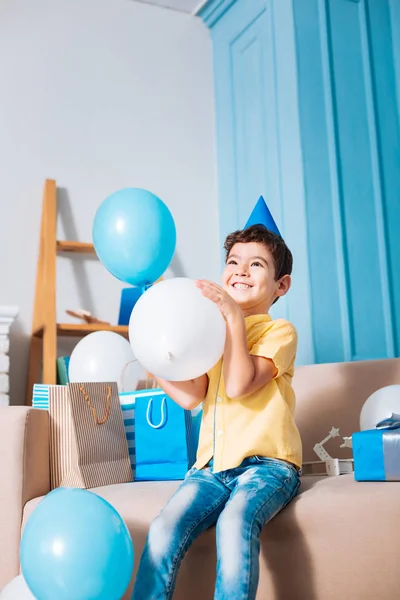 Glücklicher kleiner Junge mit Partyhut, Luftballon in der Hand und lächelnd — Stockfoto