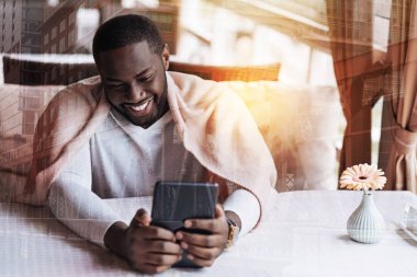 Gülümseyen adam telefonunu kullanarak