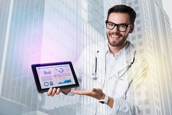 Médico sonriente positivo apuntando a la pantalla de una tableta — Foto de Stock