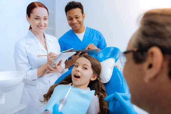 Bella ragazza piacevole guardando il suo dentista — Foto Stock