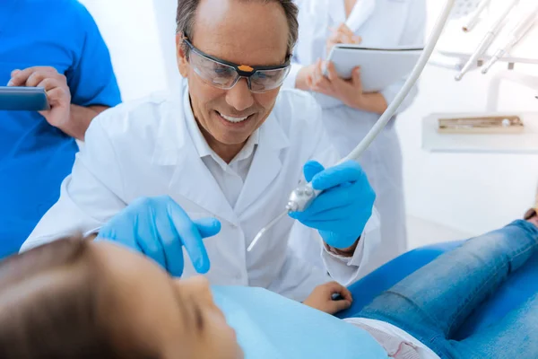 Positive smart dentist wearing protective glasses — Stock Photo, Image