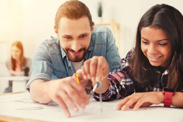 Dos jóvenes midiendo la distancia en un esquema — Foto de Stock