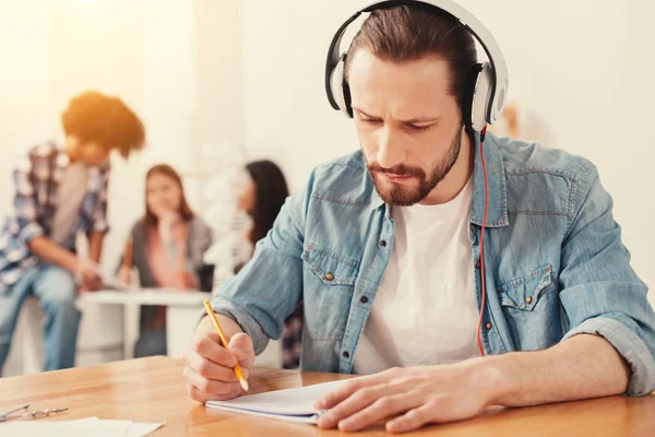 Konzentrierter bärtiger Mann schreibt einen Test — Stockfoto