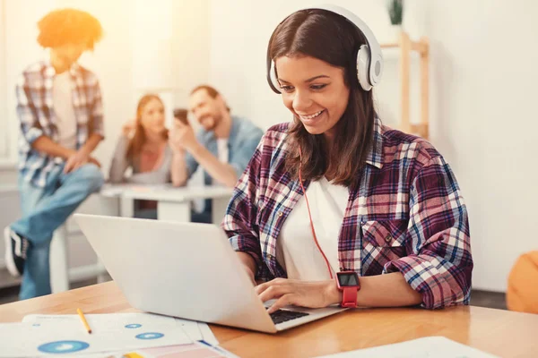 Jovencita alegre trabajando en un ordenador portátil — Foto de Stock