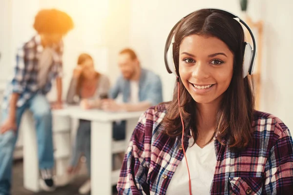 Estudante sorridente bonita em fones de ouvido — Fotografia de Stock