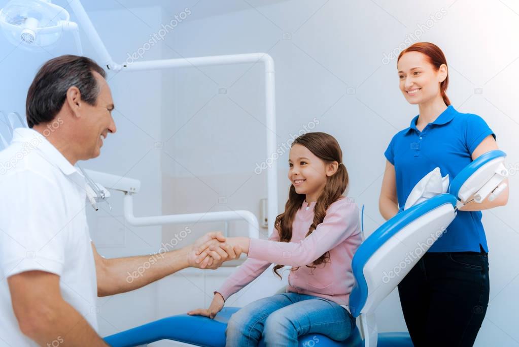 Delighted positive girl greeting her doctor