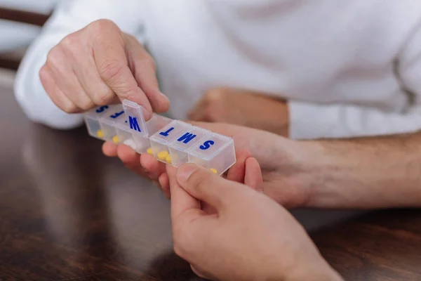 Vackra praktiska piller låda i händerna på en senior person — Stockfoto