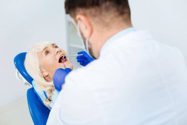 Yetenekli diş hekimi hastanın incelenmesi