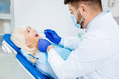 İş yerinde maske ile profesyonel diş hekimi