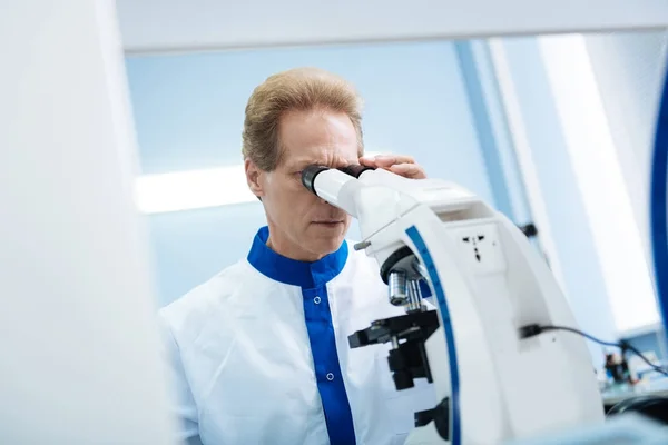 Ernstige wetenschapper op zoek naar een Microscoop — Stockfoto