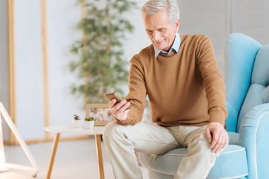 Mesajý okurken gülümseyen kıdemli mutlu adam