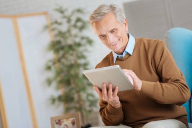 Touchpad üzerinde çalışma ve gülümseyen rahat yaşlı beyefendi