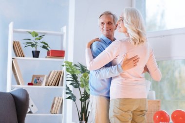 Neşeli karı koca dans sırasında gülümseyen