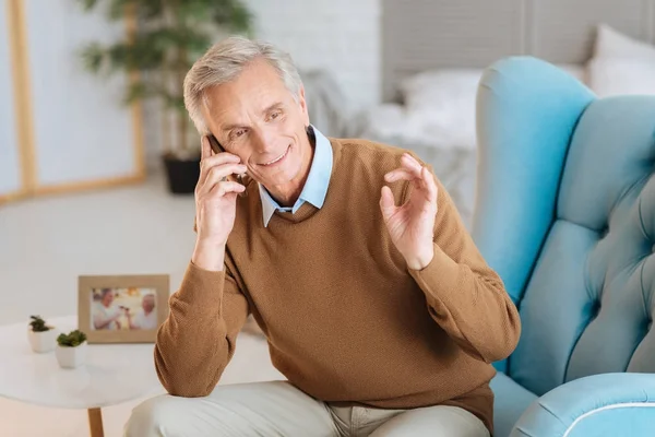 Allegro uomo anziano gesticolare mentre parla al telefono — Foto Stock