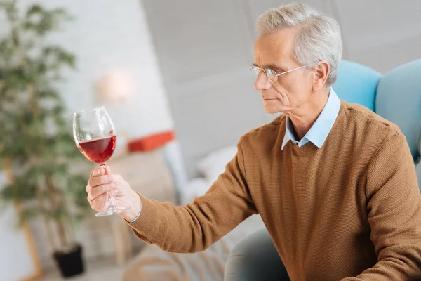 Komoly nyugdíjas férfi vizsgálata pohár vörös bor — Stock Fotó
