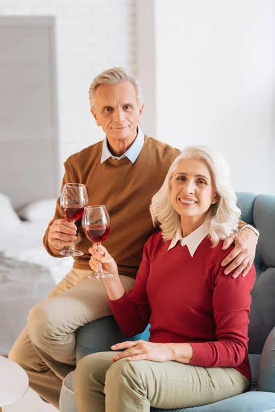 Joyful pensionerad par som njuter av sina glasögon av rött vin — Stockfoto