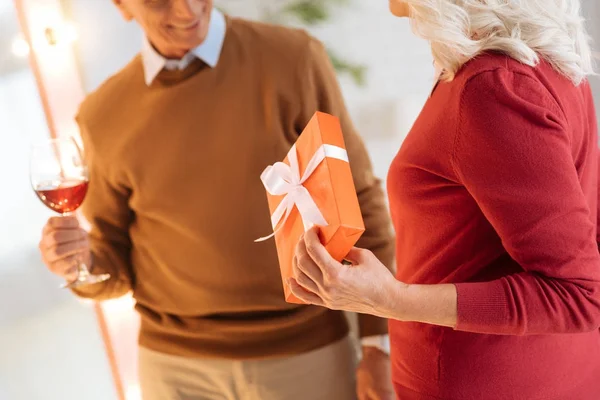 Nahaufnahme einer Rentnerin, die ihrem Mann ein Geschenk macht — Stockfoto