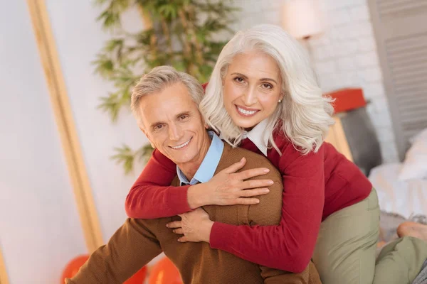Lycklig senior hustru omfamnar hennes man och ler — Stockfoto