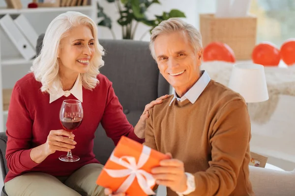 Прекрасная пара на пенсии обменивается подарками во время празднования юбилея — стоковое фото