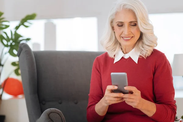 Mulher relaxada navegando na internet em seu smartphone — Fotografia de Stock