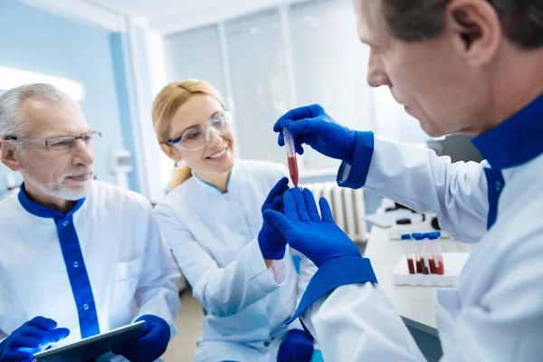 Усміхнена команда вчених, що проводять дослідження крові — стокове фото