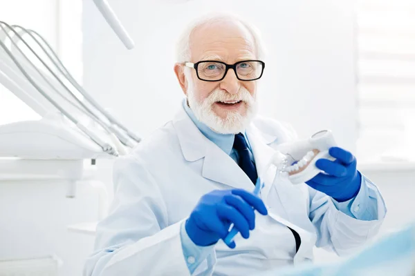 Mirada optimista del dentista experto con dientes postizos — Foto de Stock