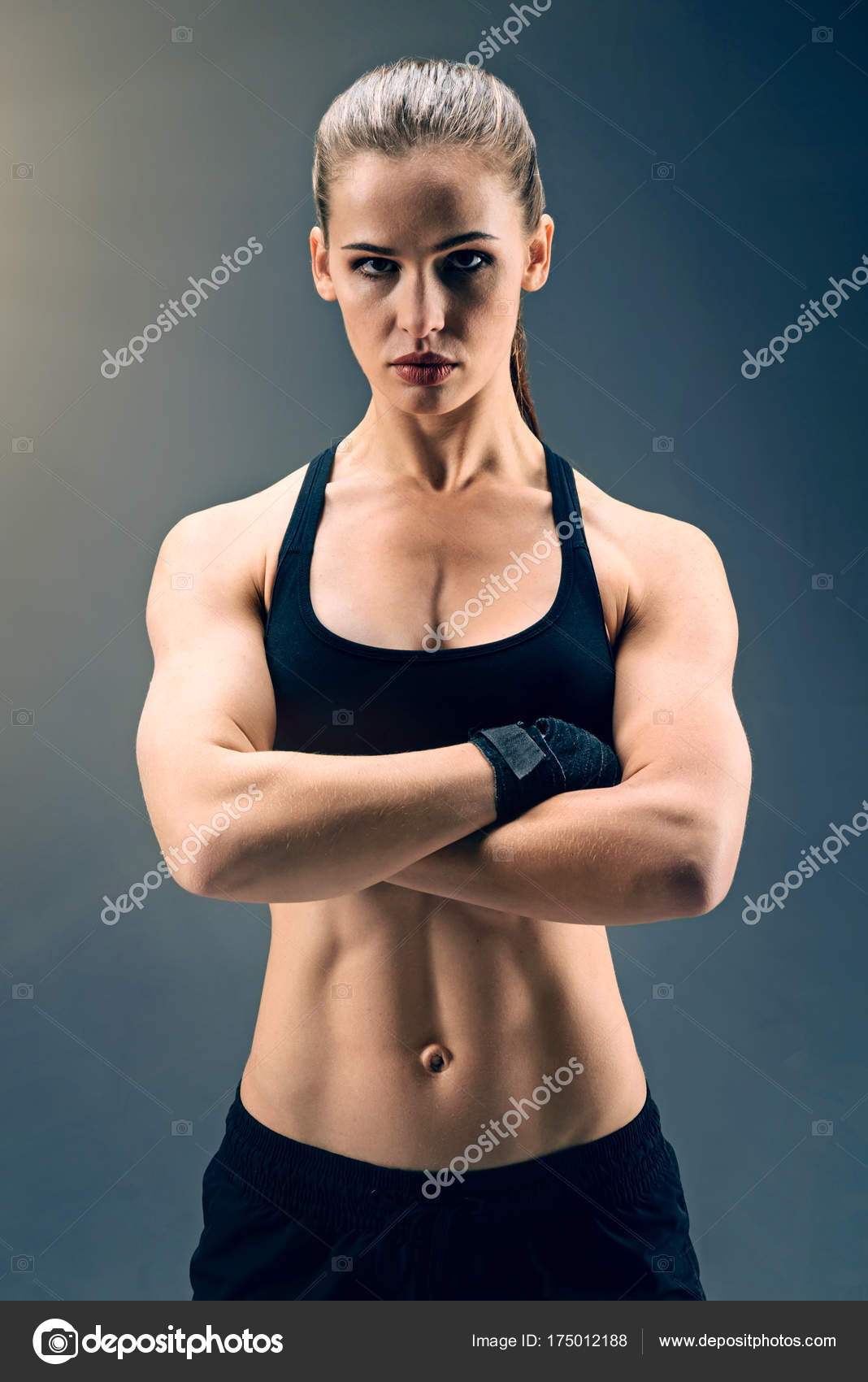 Muscular sporty lady posing with arms crossed Stock Photo by ©yacobchuk1  175012188