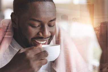 Pozitif adam içkisini tadını çıkarırken neşeyle gülümseyen