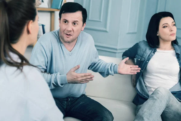 Заплутана емоційна людина розмовляє зі своїм психологом — стокове фото