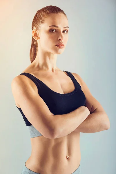 Pretty and strong sportswoman posing with arms crossed — Stock Photo, Image