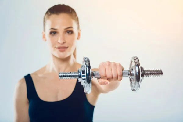 Jovem em forma e forte fitness menina segurando halteres — Fotografia de Stock