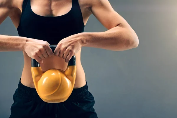 Zbliżenie na lekkoatletka zniesienia kettlebell oburącz — Zdjęcie stockowe