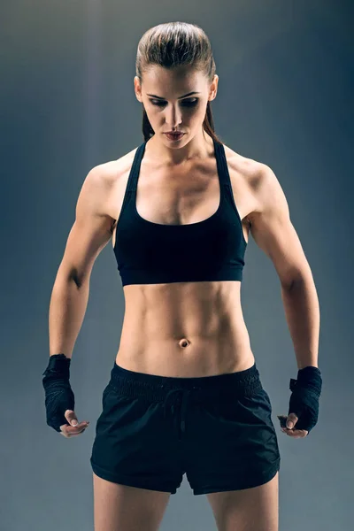 Sterke krachtige vrouwelijke bokser over donkere achtergrond — Stockfoto