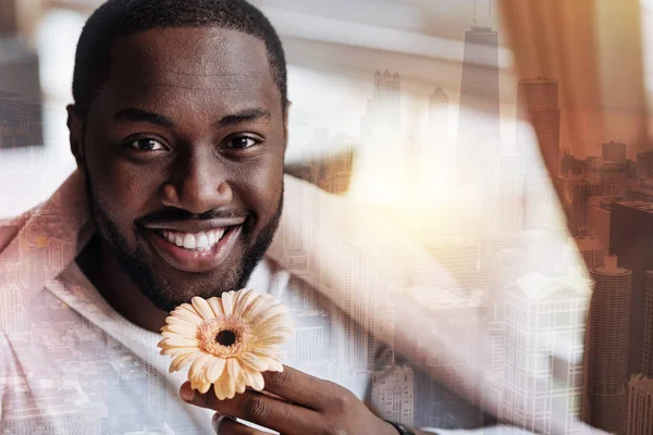 英俊的年轻人拿着一朵花看着快乐 — 图库照片