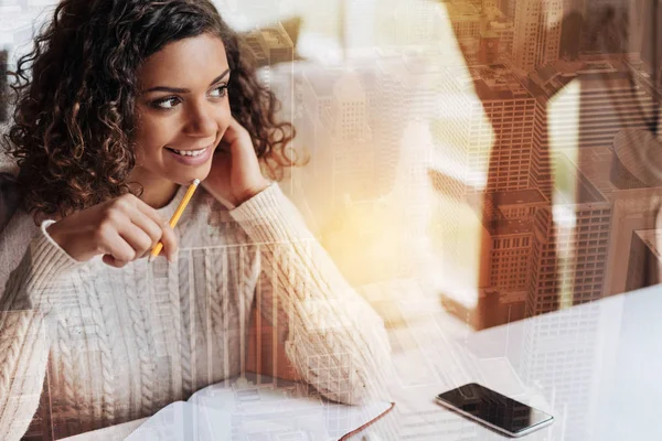 stock image Cheerful young woman sitting and smiling while working