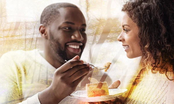 Close up of African American feeding his woman with a cake — Stock Photo, Image