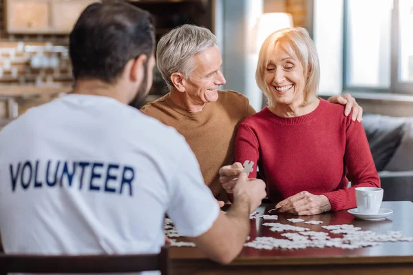 Nöjd äldre dam spendera en tid med sin make och deras volontär — Stockfoto