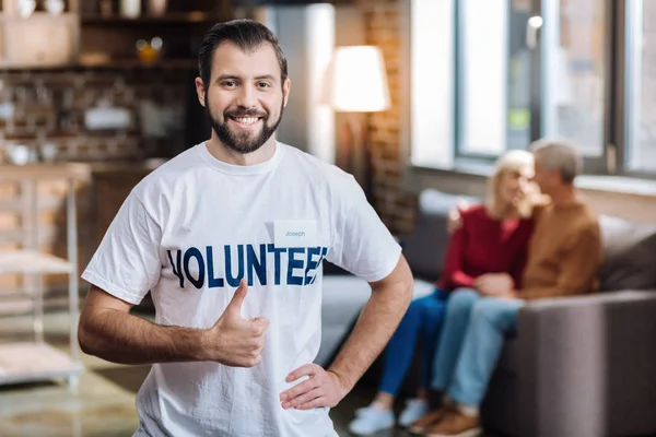 Enthousiaste vrijwilligers op zoek gelukkig terwijl het helpen van mensen — Stockfoto