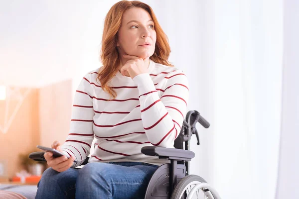 Mujer discapacitada concentrada en silla de ruedas pensando — Foto de Stock