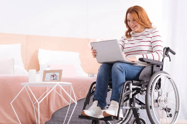 Innehåll handikappad kvinna använder sin laptop — Stockfoto